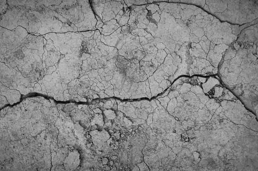 Gray cracked concrete texture background, close up chemical grouting